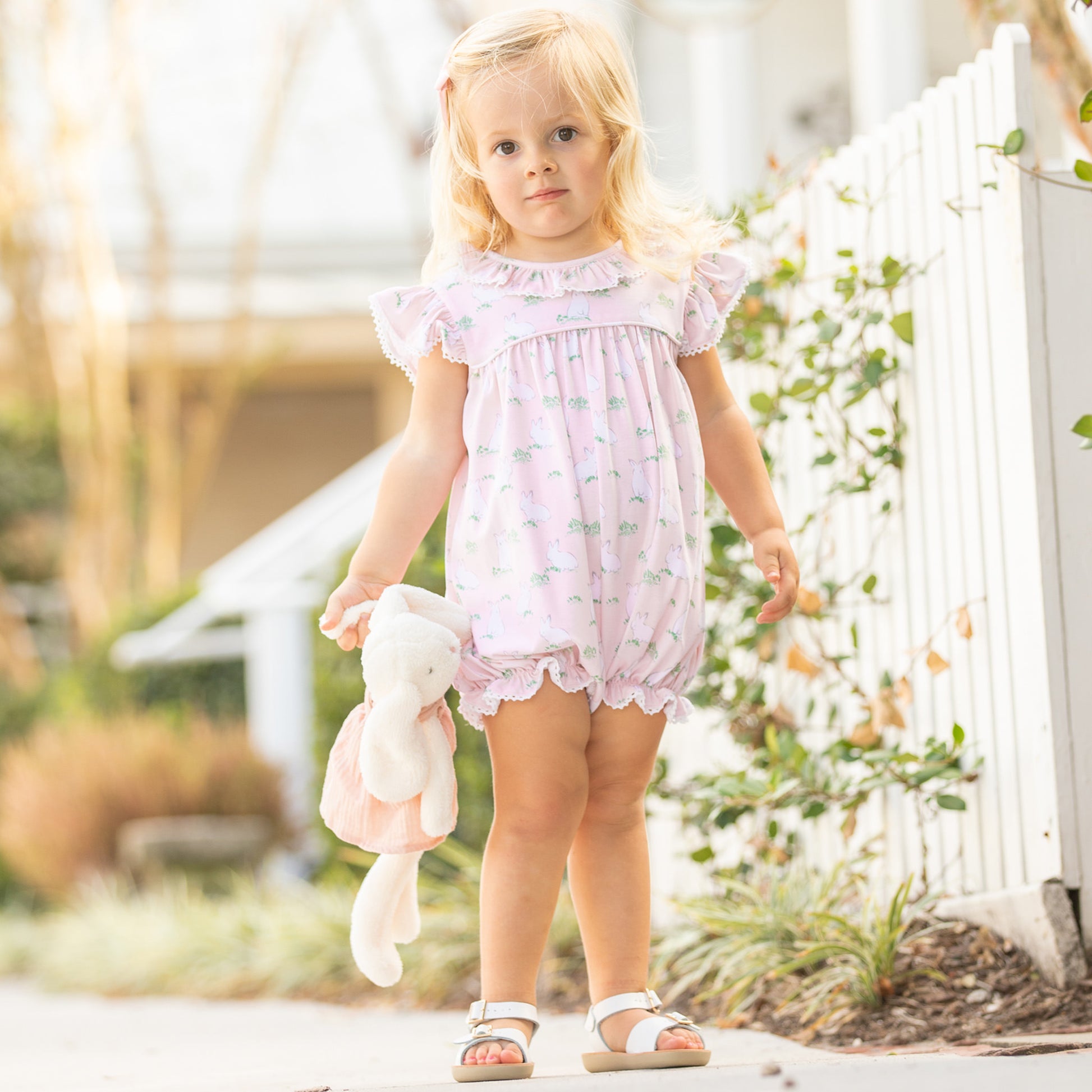 little girl wearing Hippity Hoppity Knit Bubble walking down a sidewalk
