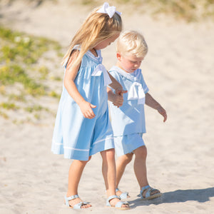 little boy and little girl holding hands on the beach