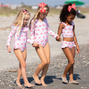 three little girls at the beach with cute bows in their hair