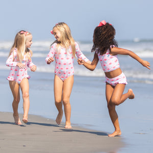 three little girls running down the beach
