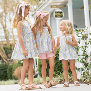 three little girls smiling at each other