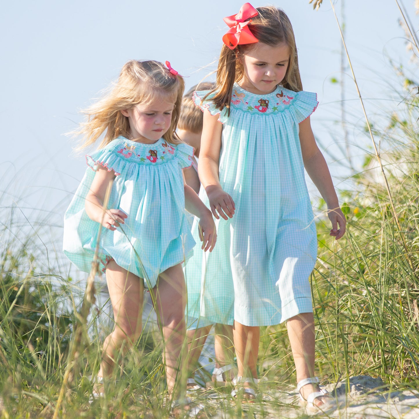 2 little girls and their brother walking on the beach path