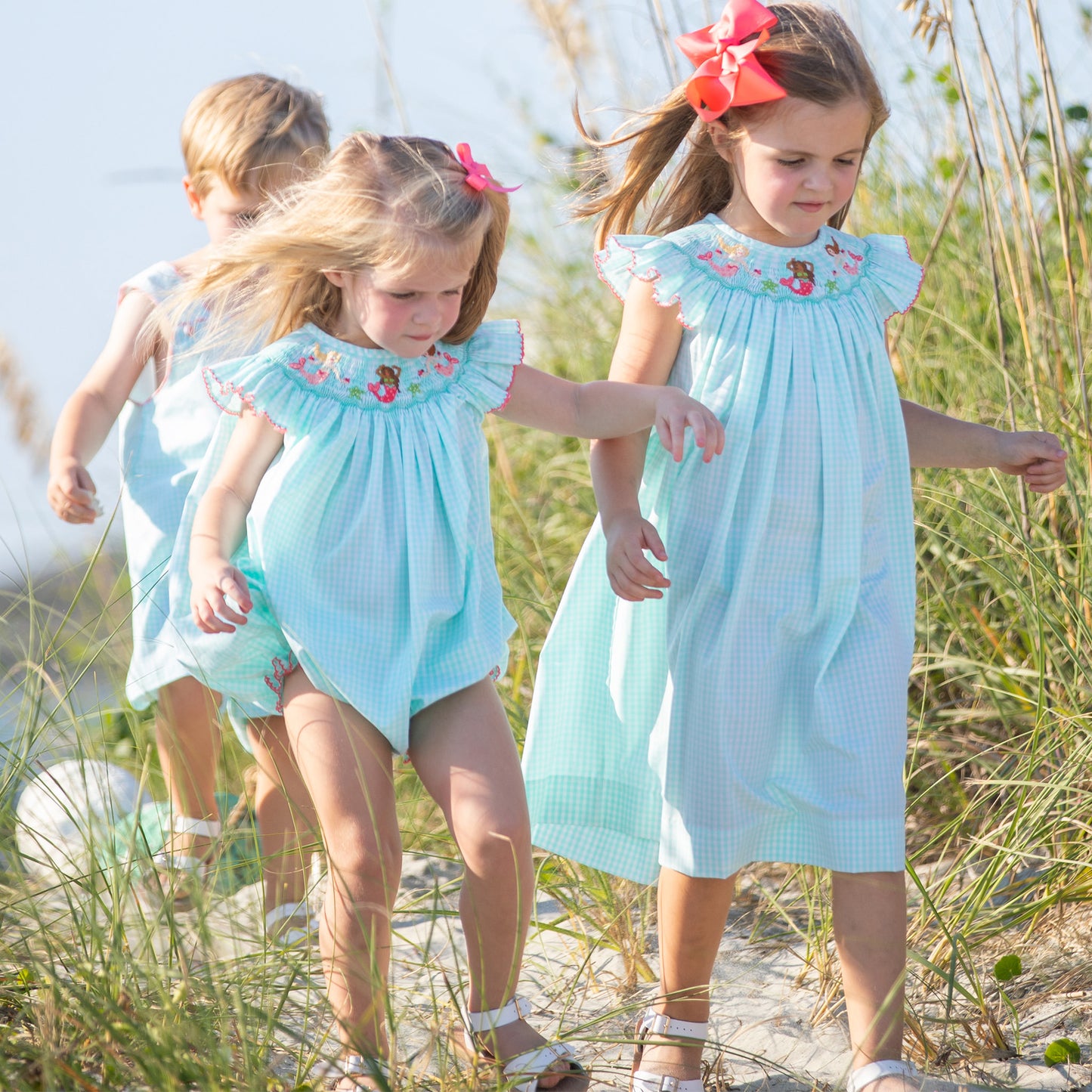 little girl wearing Under The Sea Smocked Bubble with her sister and brother at the beach