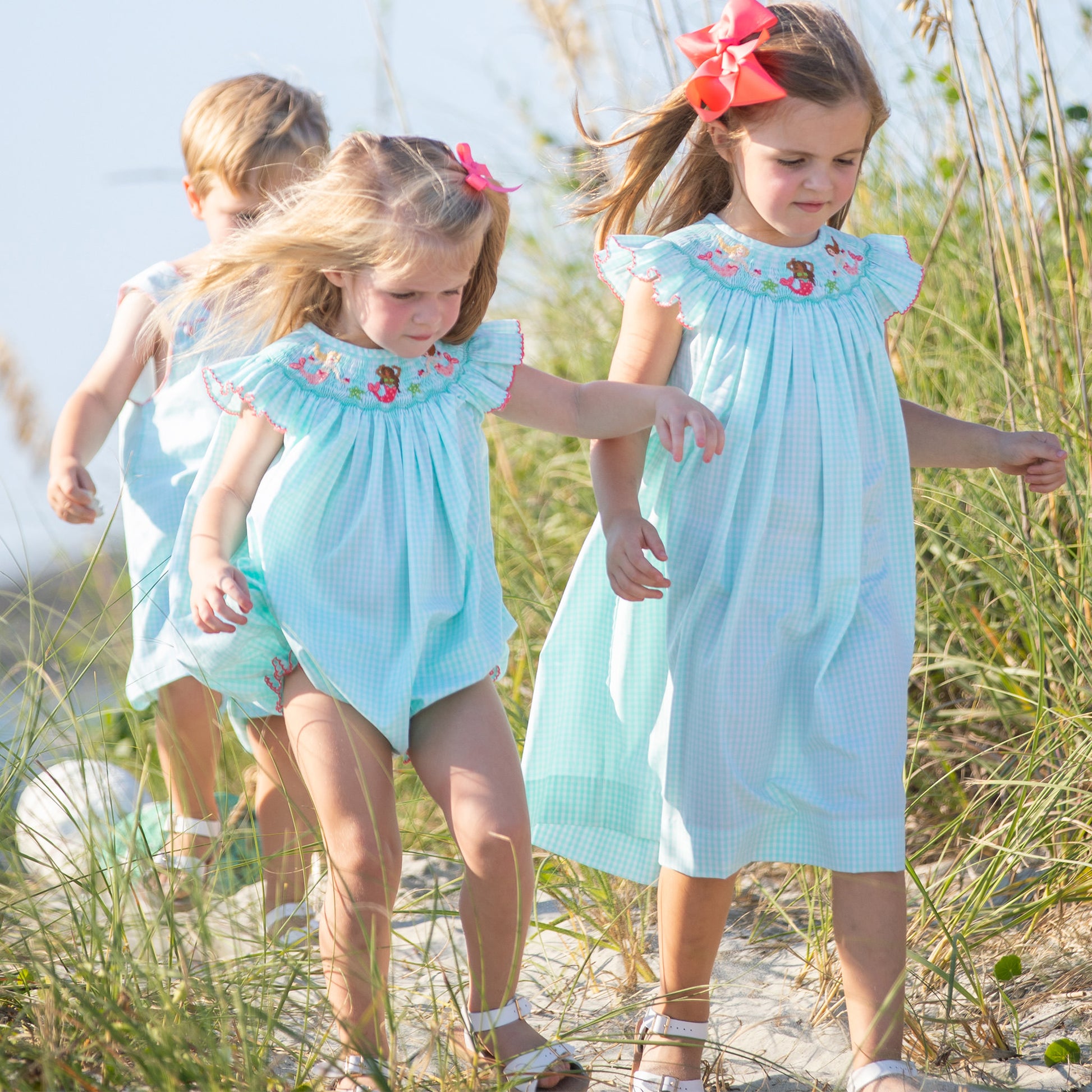 little girl wearing Under The Sea Smocked Bubble with her sister and brother at the beach