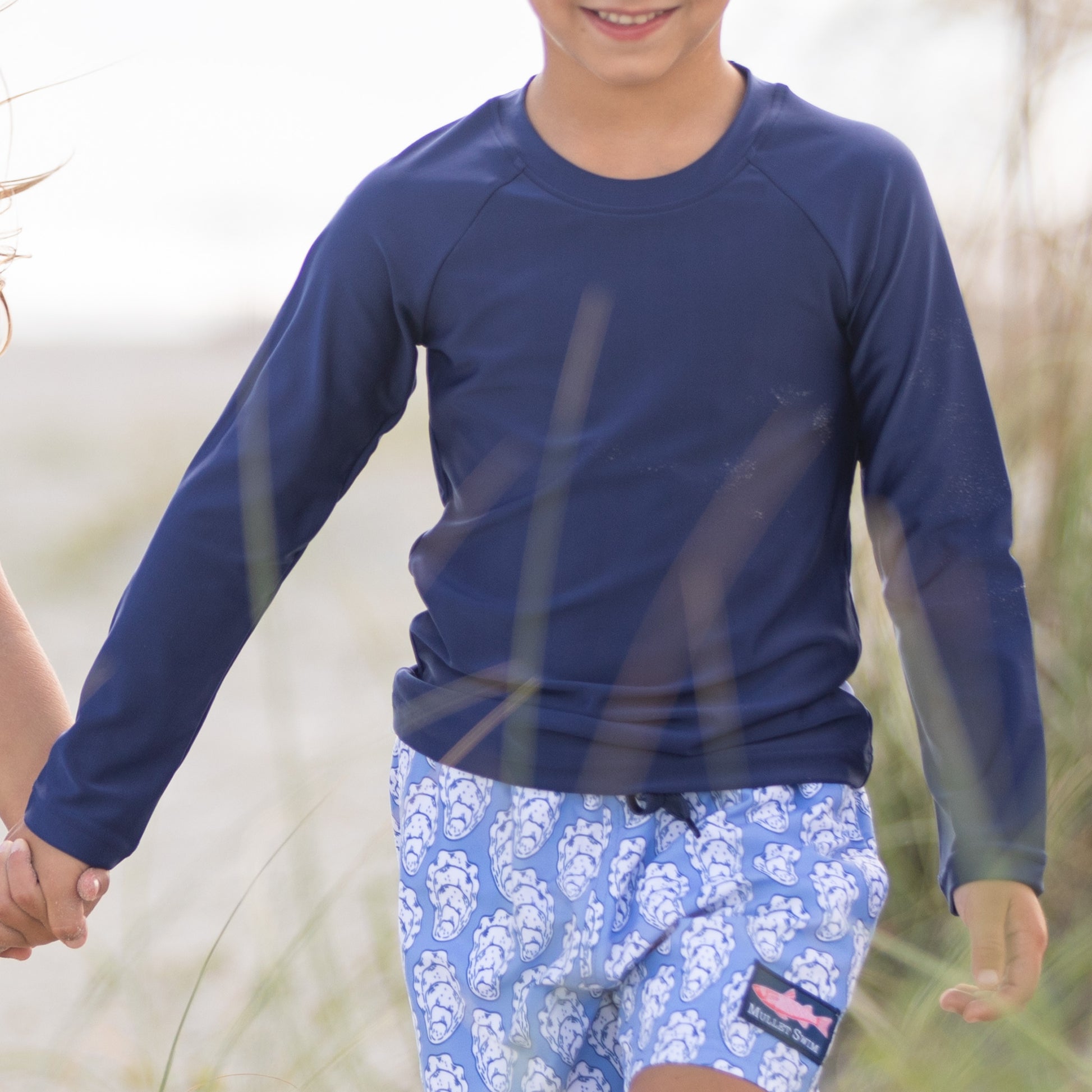 little boy on the beach wearing Boys Navy Rashguard