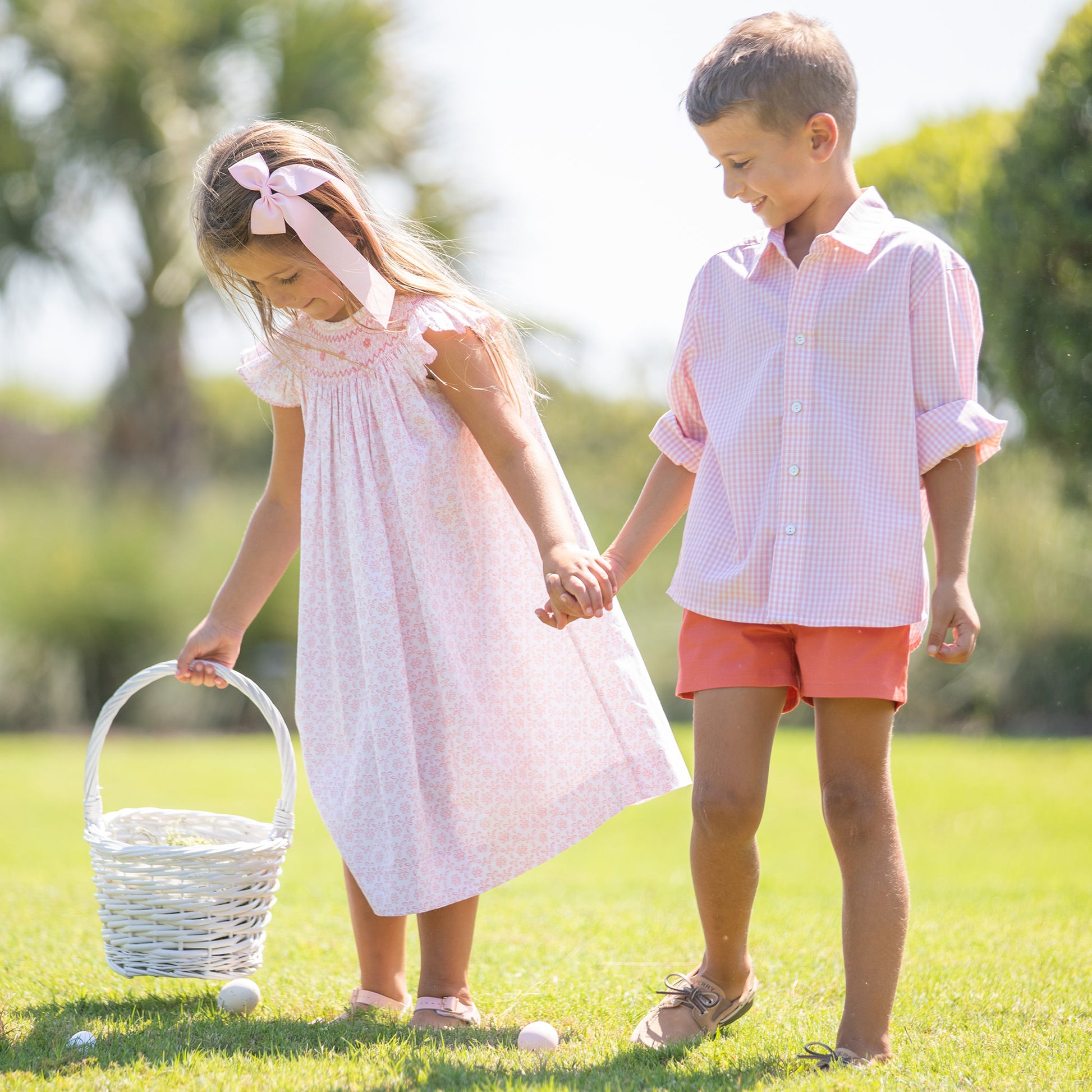 little girl holding a little boys hand who's wearing Pink Check Oxford at an Easter egg hunt