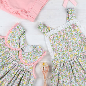 flatlay of Tybee Floral Swing Top, pink shorts and flowered jumper