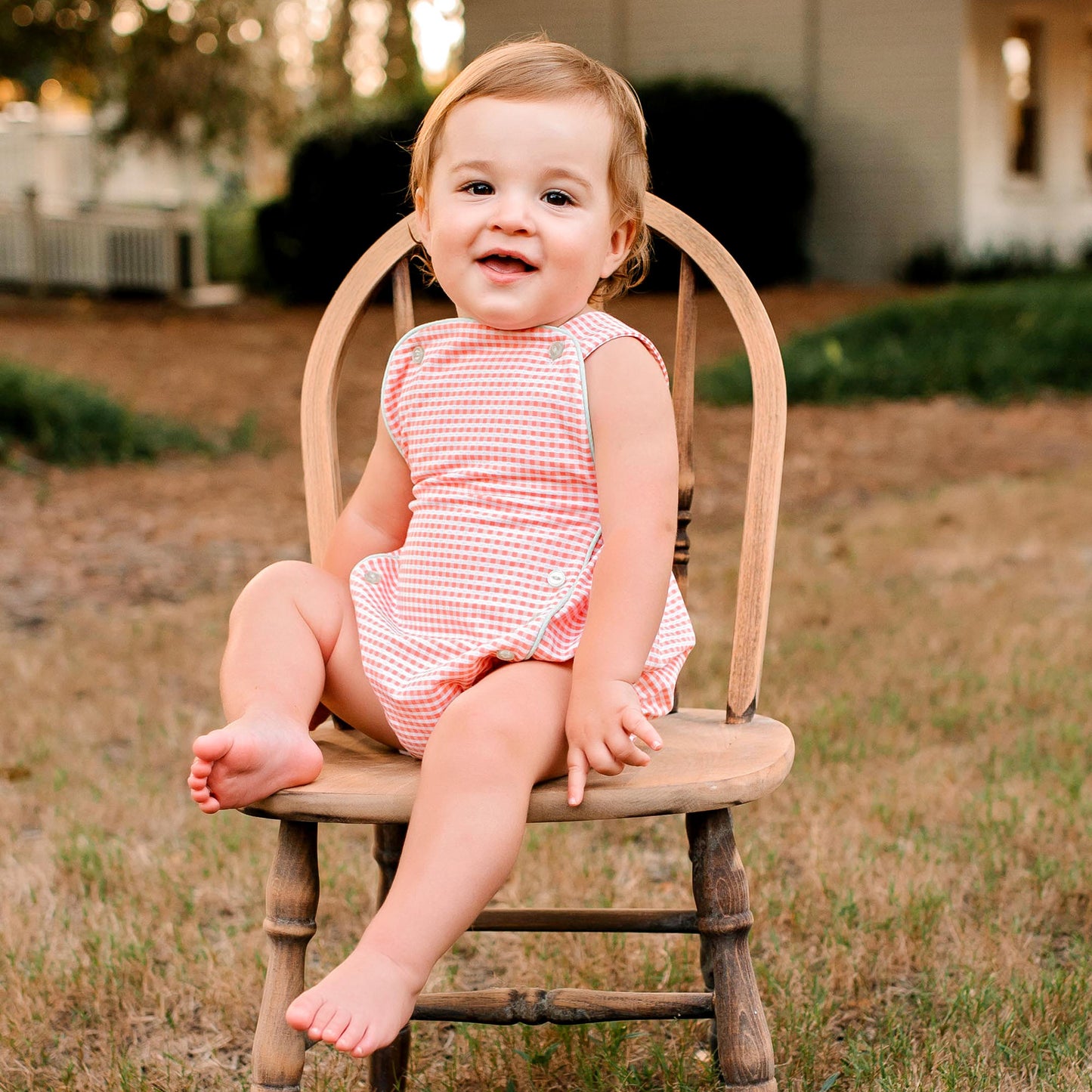 smiling baby sitting in a chair wearing Unisex Picnic Check Romper