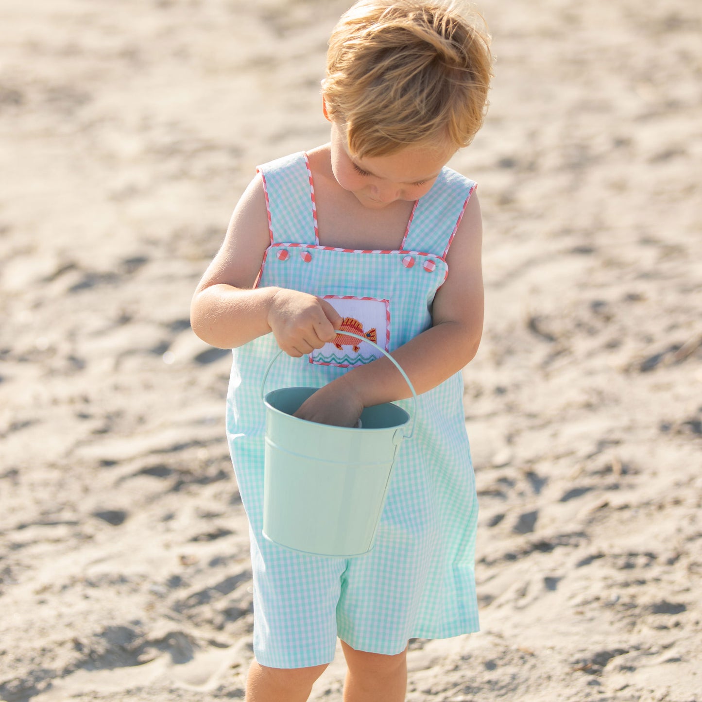 little boy on the beach wearing Under The Sea Smocked Shortall