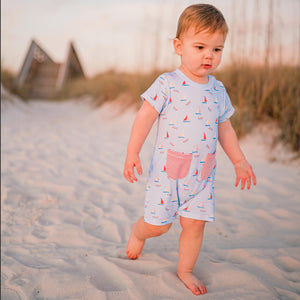 little baby walking in the sand at the beach