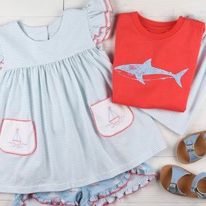 flatlay of Botany Bay Stripe Shorts and a shark shirt and blue sandals