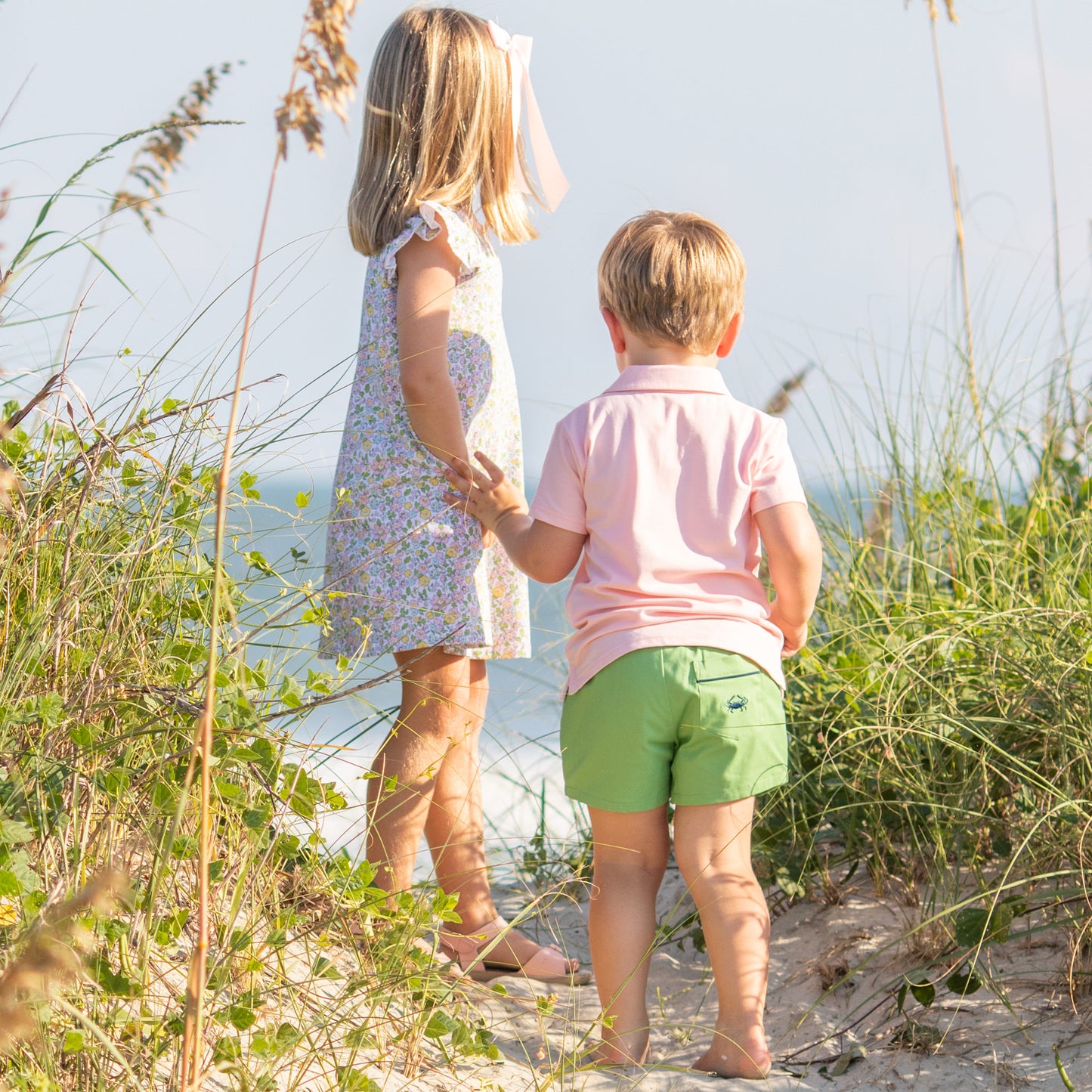 little boy wearing Pink Cotton Knit Polo holding his sister's hand at the beach